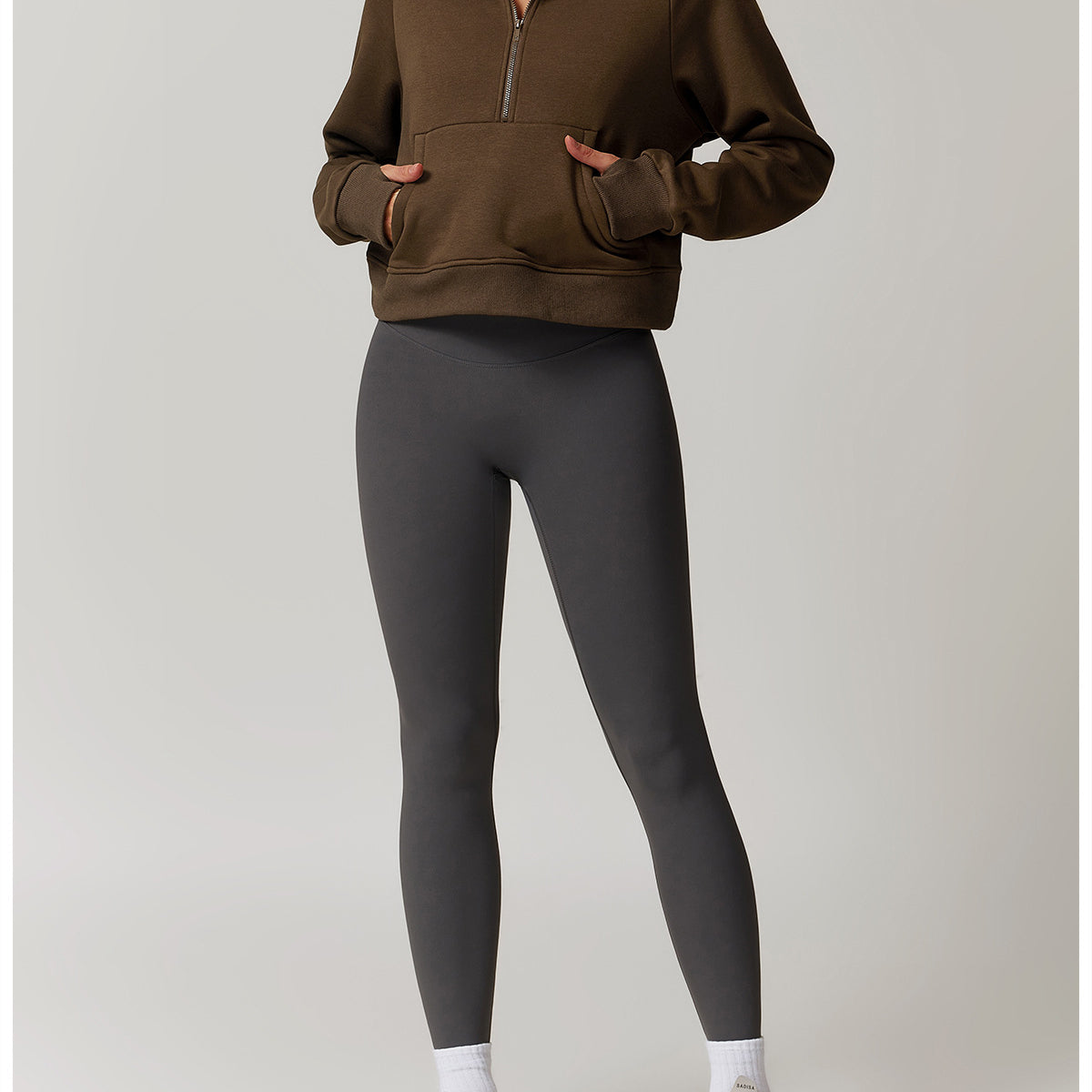 Brown half-zip pullover sweater with pockets styled with grey leggings and white sneakers, fashion ملابس