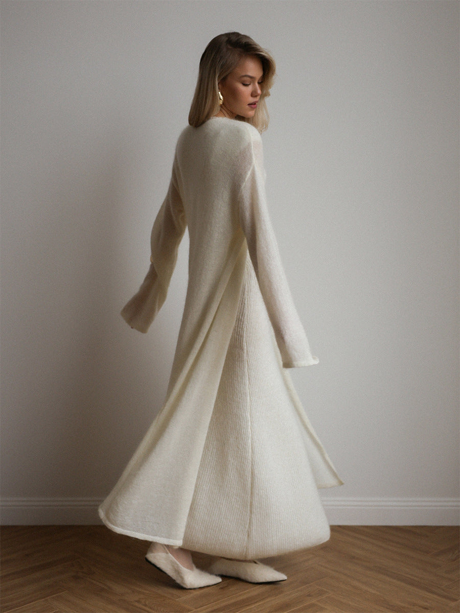 Cream-colored knitted cardigan with fur trim over sleeveless dress
