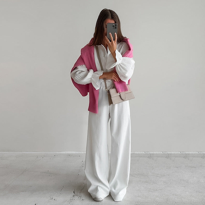 Woman wearing white pure cotton homewear with blouse, wide-leg trousers, pink sweater