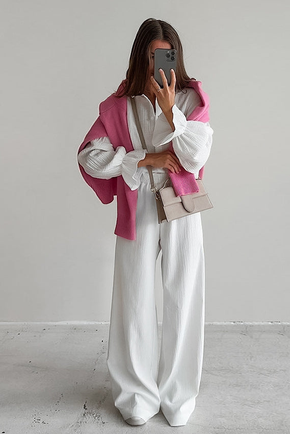 Woman wearing white pure cotton homewear with blouse, wide-leg trousers, pink sweater