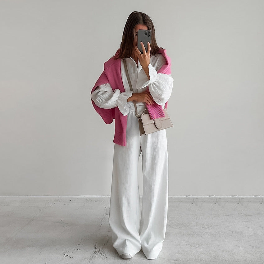 Woman wearing white pure cotton homewear with blouse, wide-leg trousers, pink sweater