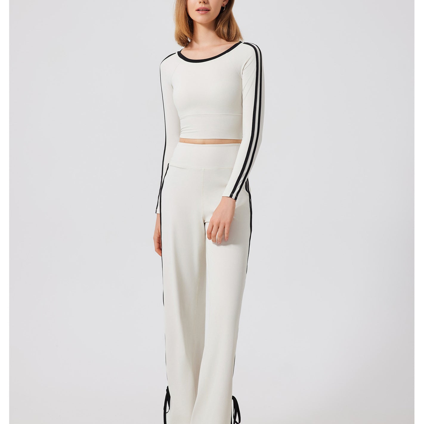 Woman’s white two-piece outfit with black stripes, fashionable quick drying sports top, ملابس