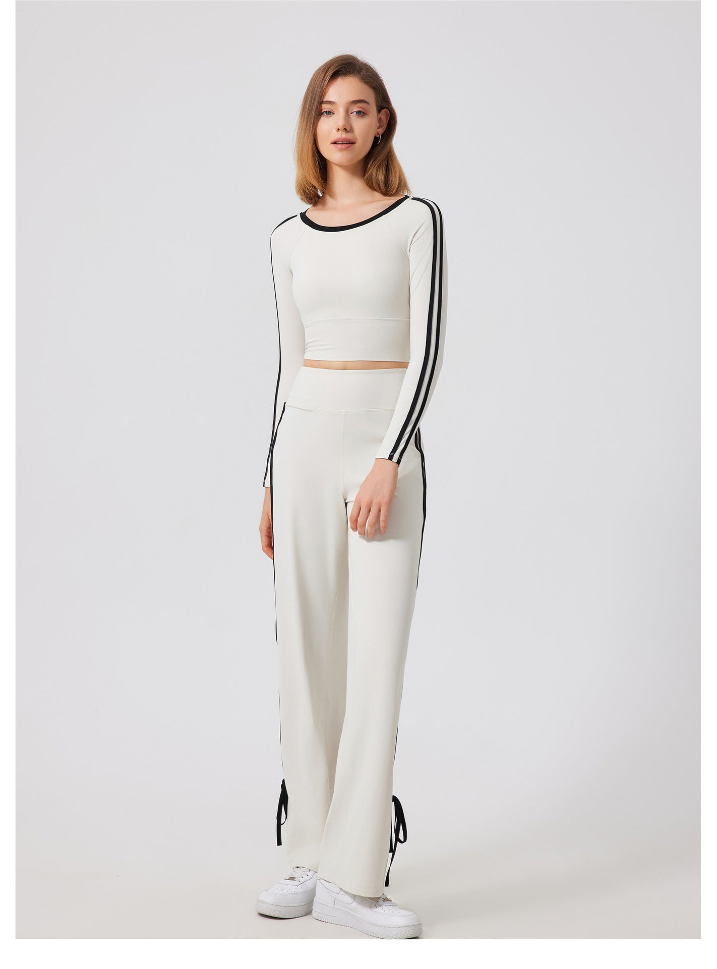 Woman’s white two-piece outfit with black stripes, fashionable quick drying sports top, ملابس