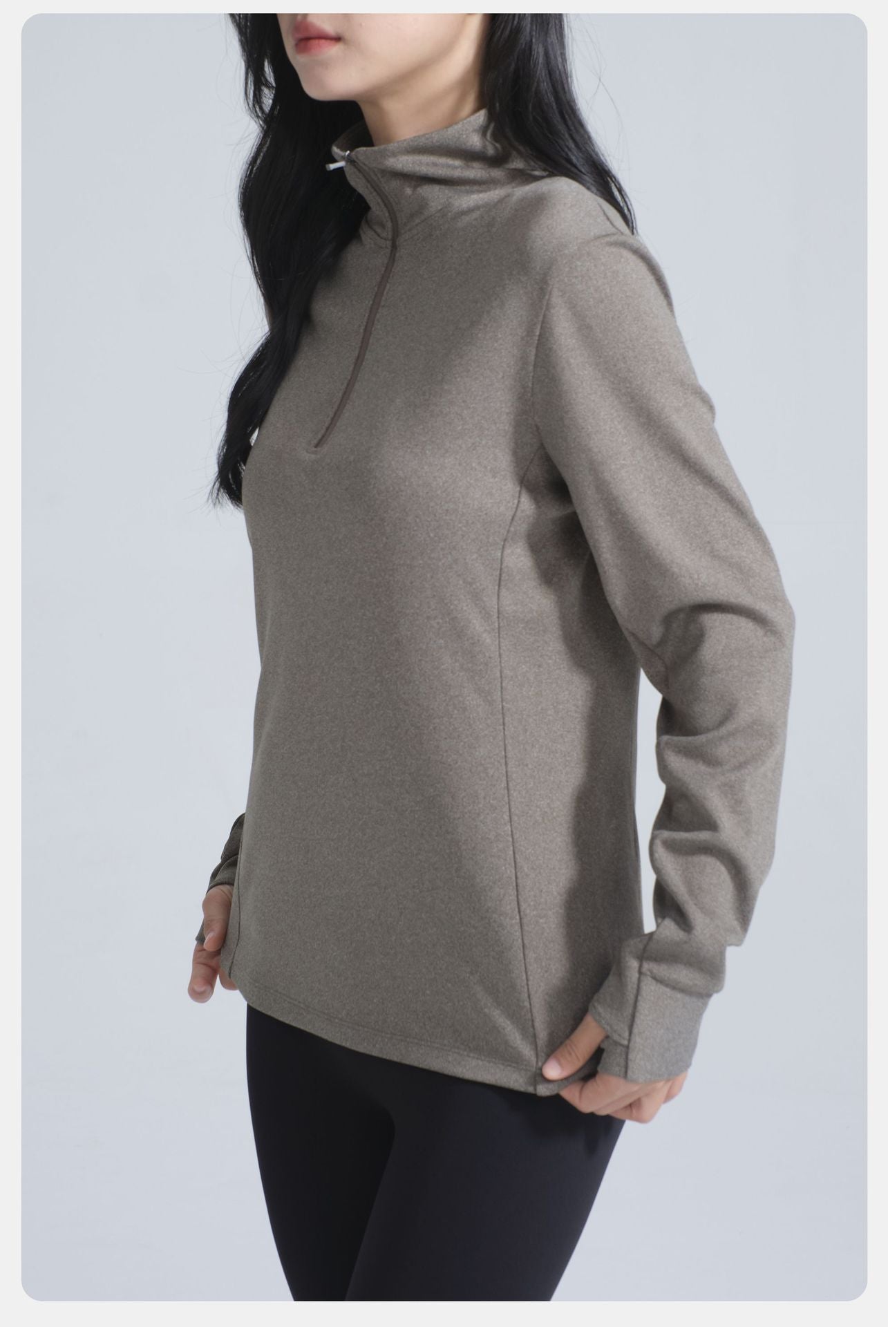 Woman wearing Winter Thermal Velvet Long Sleeved Yoga Jacket in muted olive-green with thumbholes