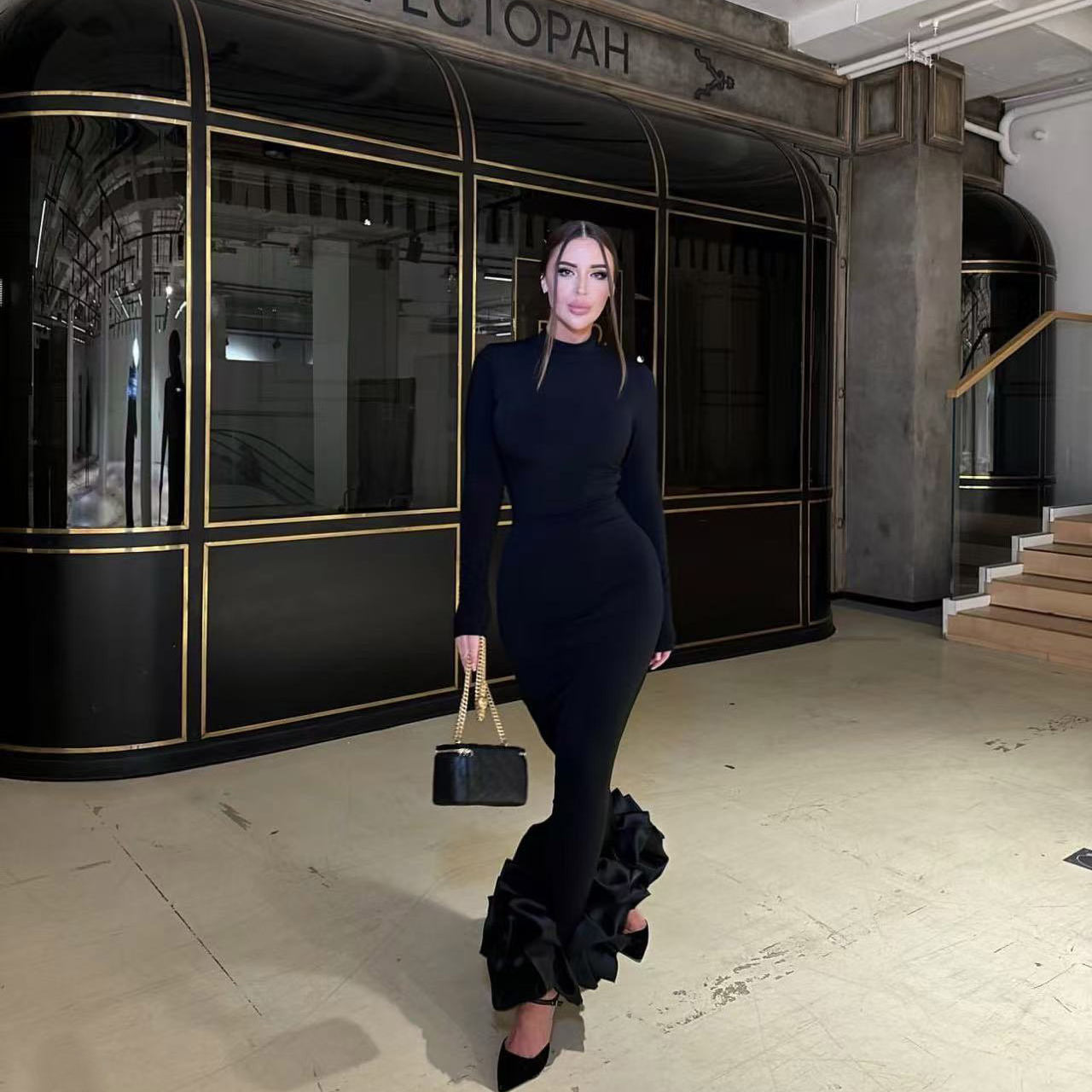 Elegant black fishtail dress with ruffled hem showcasing sophisticated fashion and ملابس style