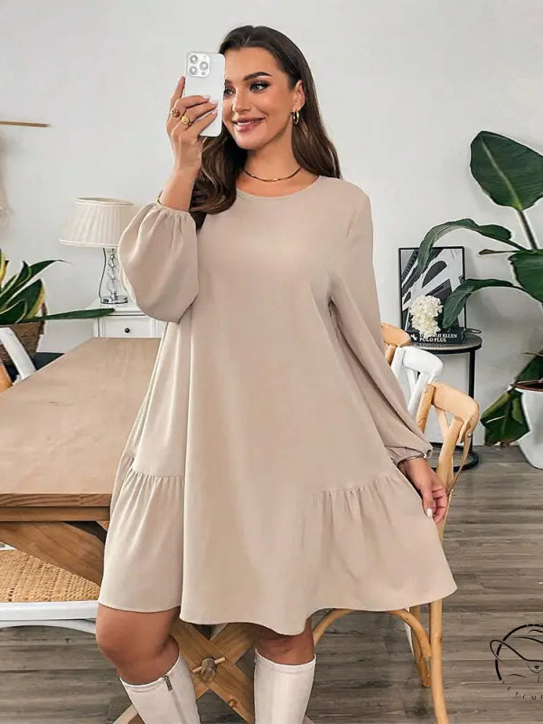 Woman in beige tiered midi dress with white knee-high boots, langry fashion