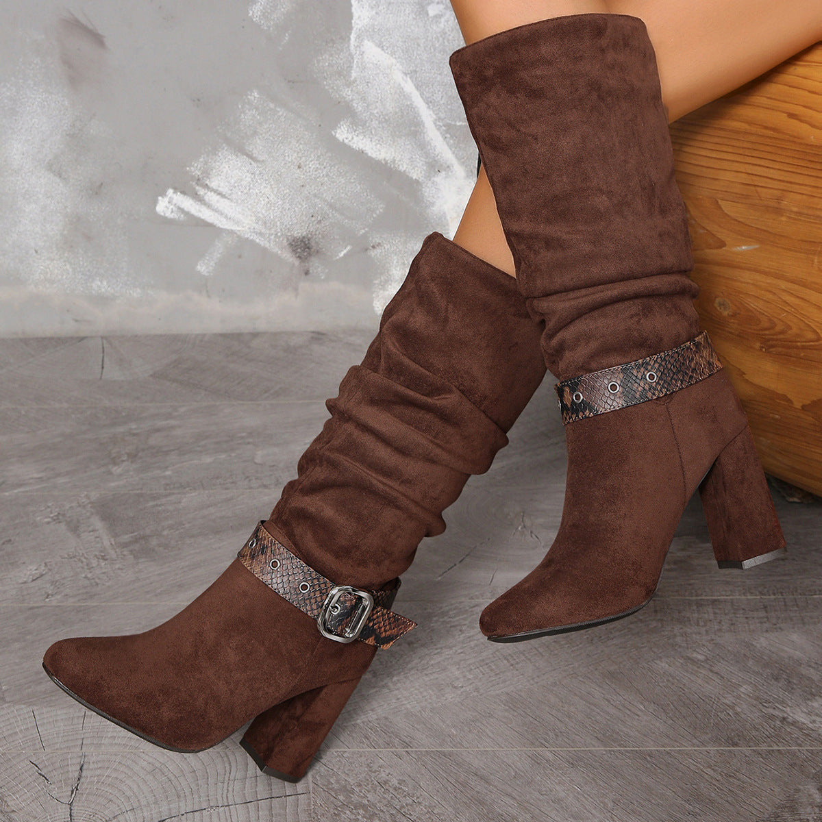 Brown suede knee-high boots with snake-print straps and chunky heels for fashion enthusiasts