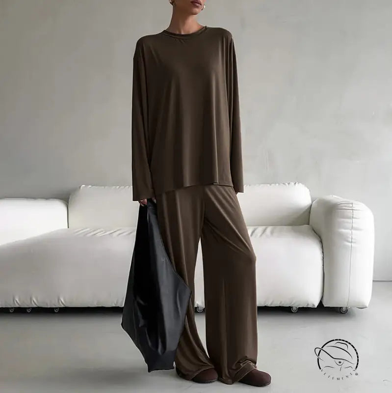 Woman in round neck loose long-sleeve brown pajama suit with wide-leg pants and tote bag