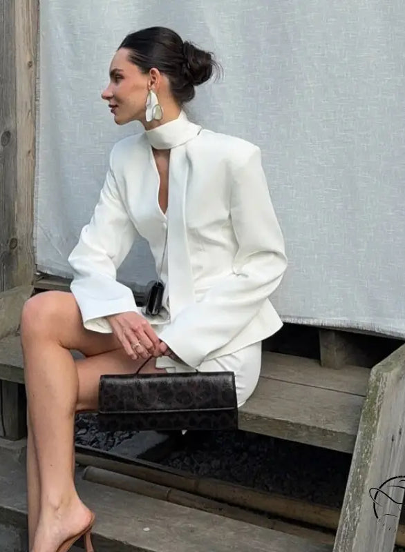 Elegant langry fashion white high-neck blouse with bell sleeves and black clutch bag in waist-tight blazer hip skirt two-piece set
