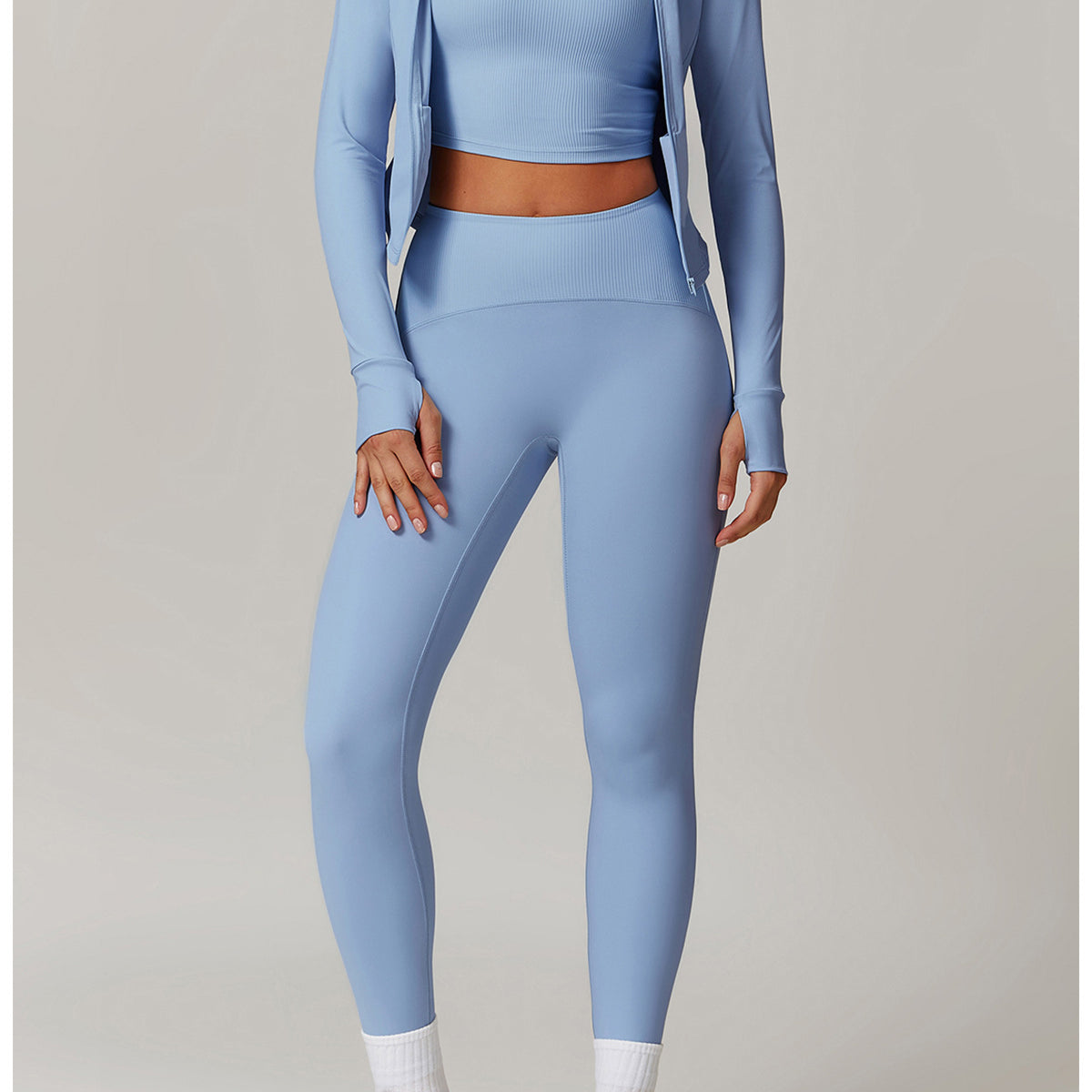 Light blue langry workout set with cropped jacket, sports bra, leggings, and white sneakers