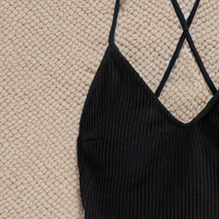 Black ribbed tank top with cross-back straps, perfect for a stylish swimwear look
