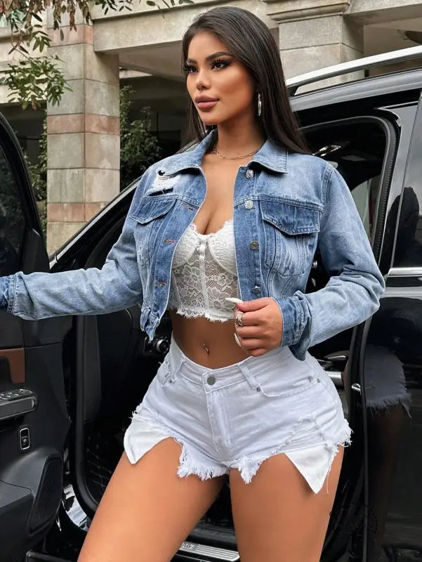 Light wash loose short denim coat with distressed details over white lace bralette and shorts