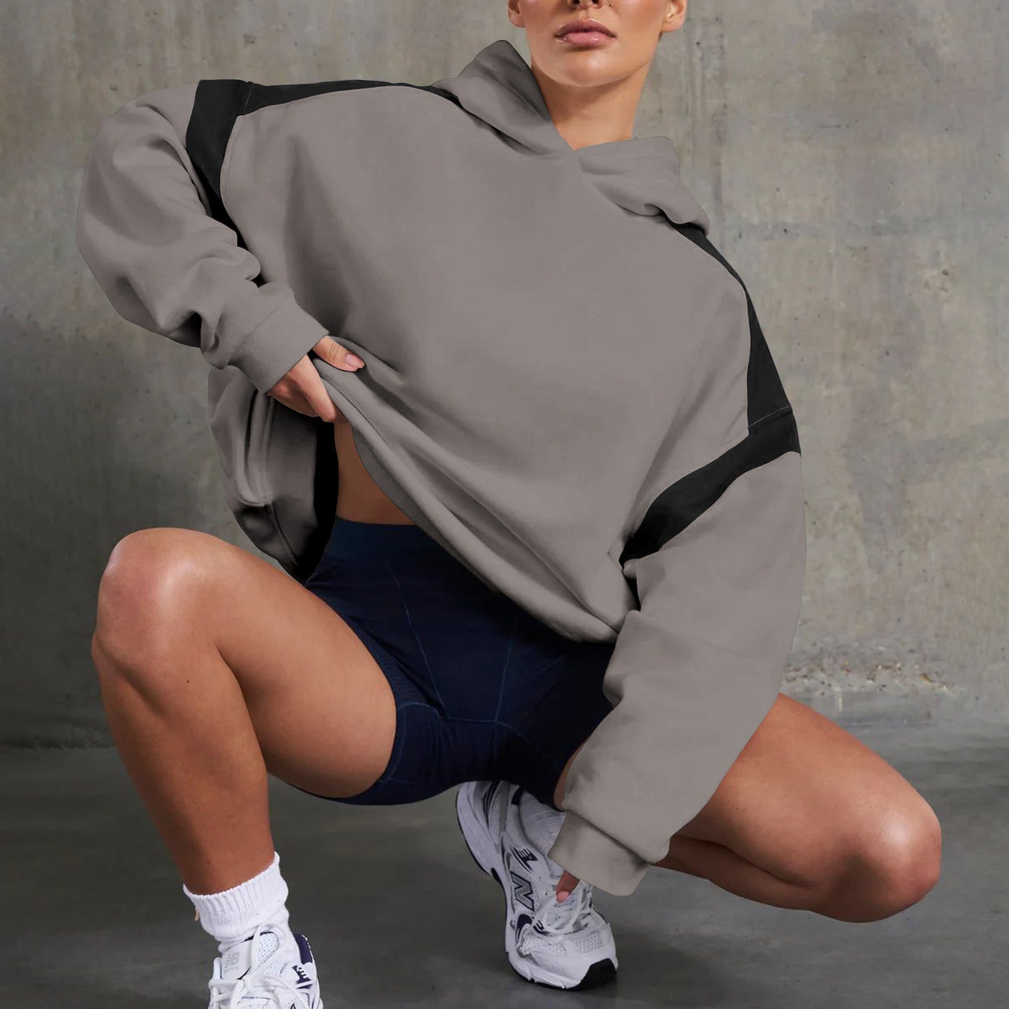 Woman in gray and black hoodie showcasing langry fashion style with navy shorts and white sneakers
