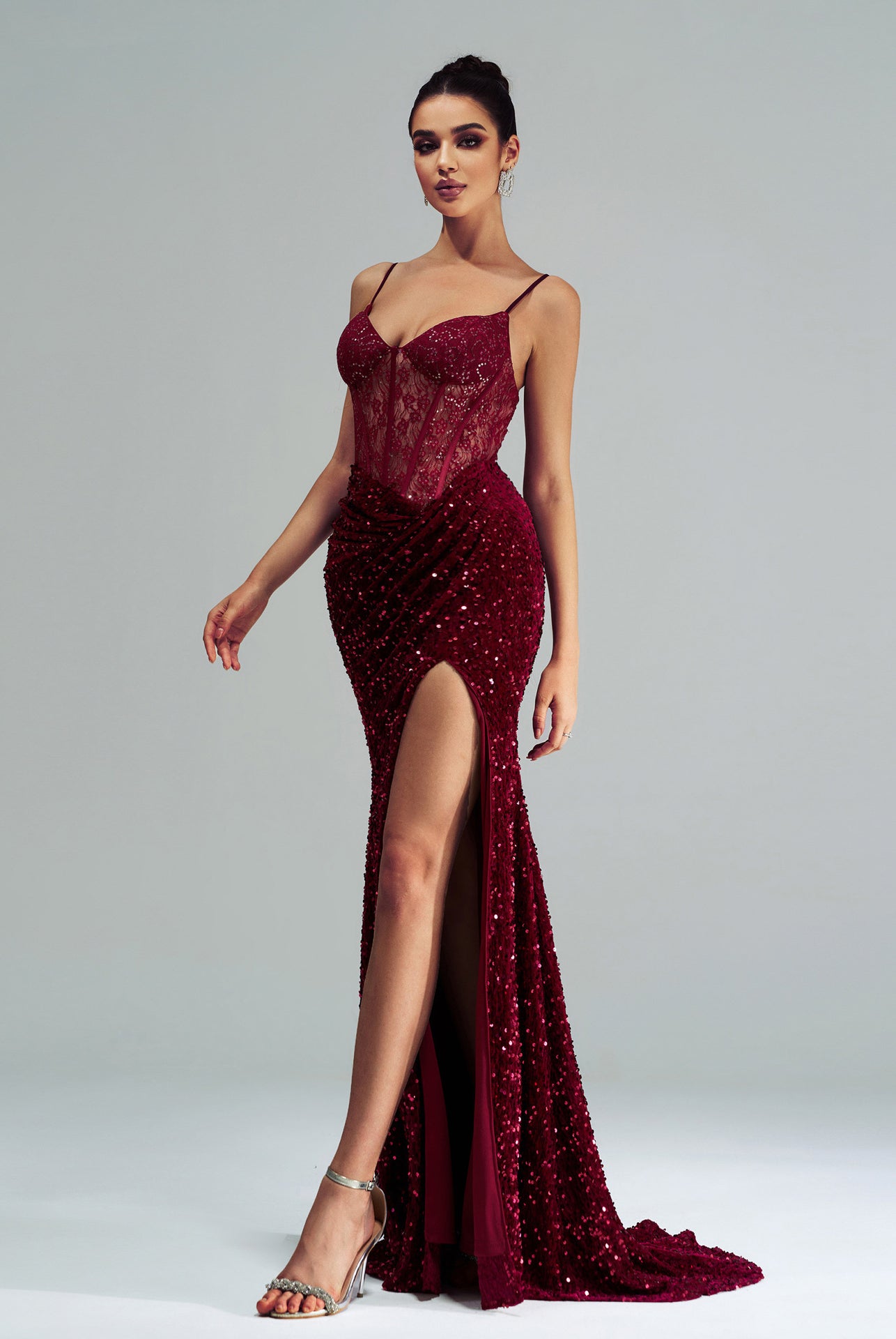 Burgundy sequined high-end evening gown with slit and spaghetti straps, perfect for fashion events