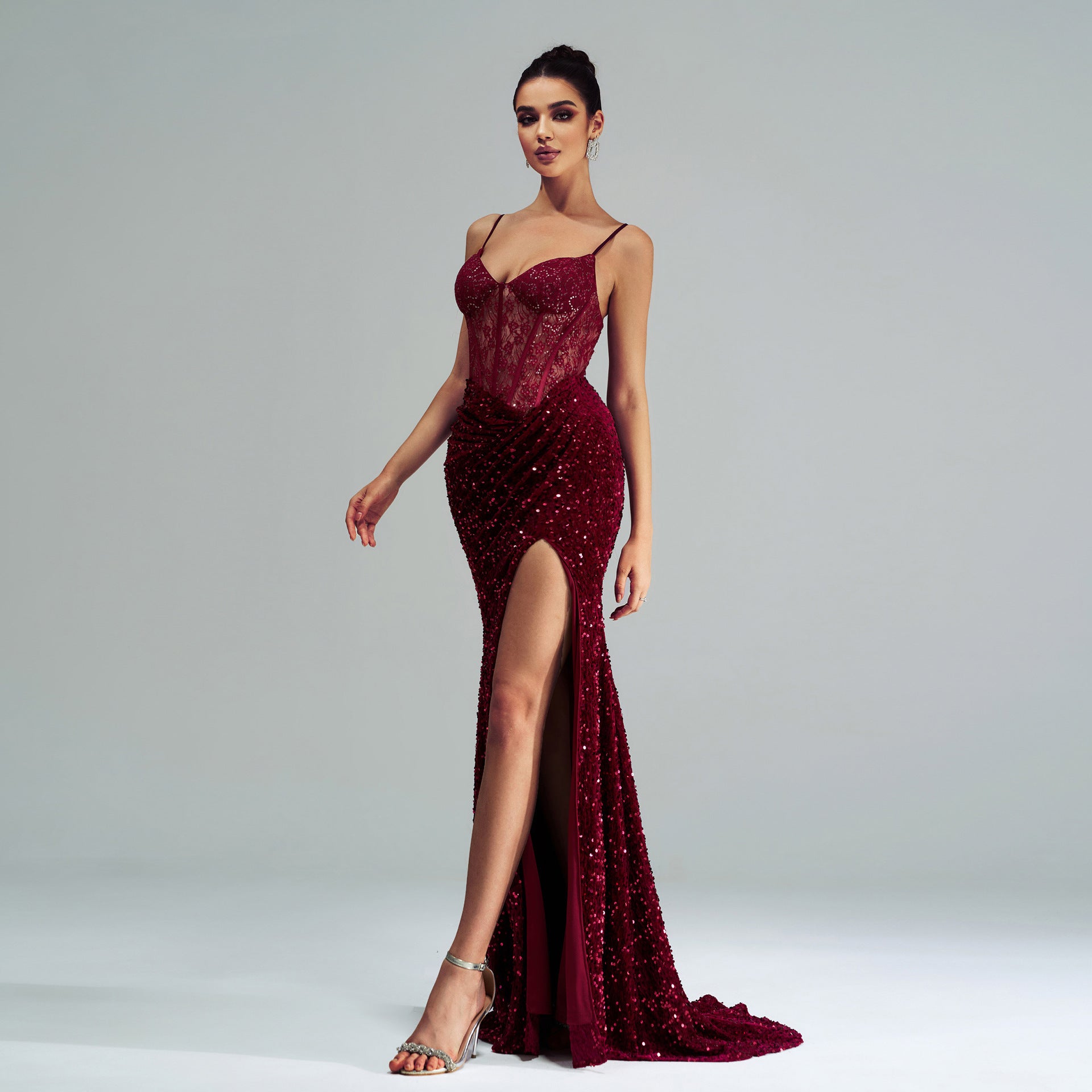 Burgundy sequined high-end evening gown with slit and spaghetti straps, perfect for fashion events