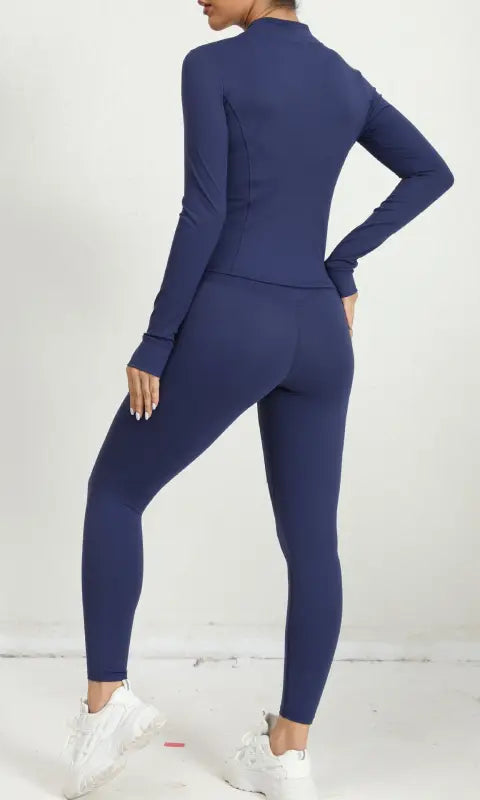 Navy blue three piece yoga clothes suit with white sneakers and high collar