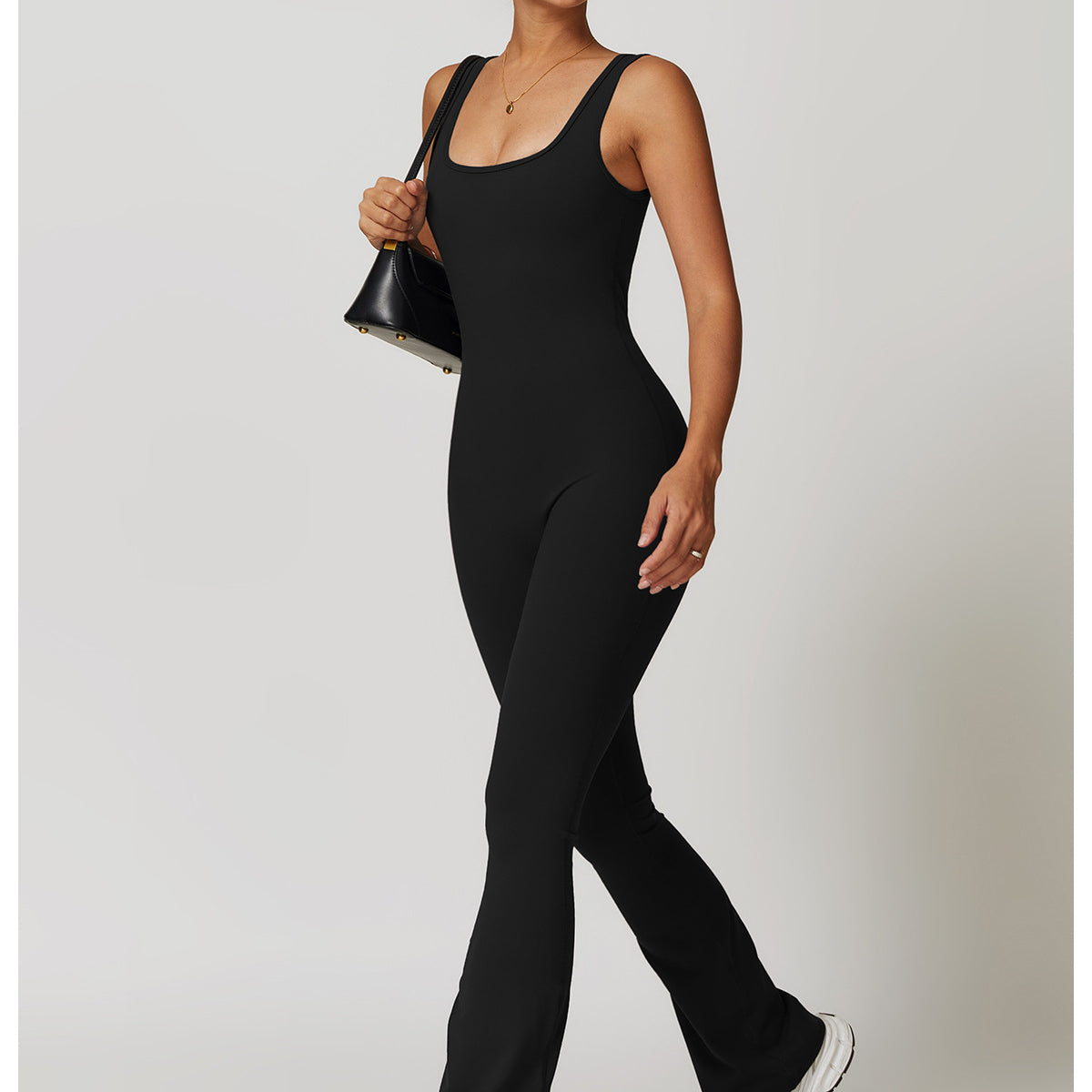 Black sleeveless flared jumpsuit in fashion with white sneakers and sunglasses for ملابس