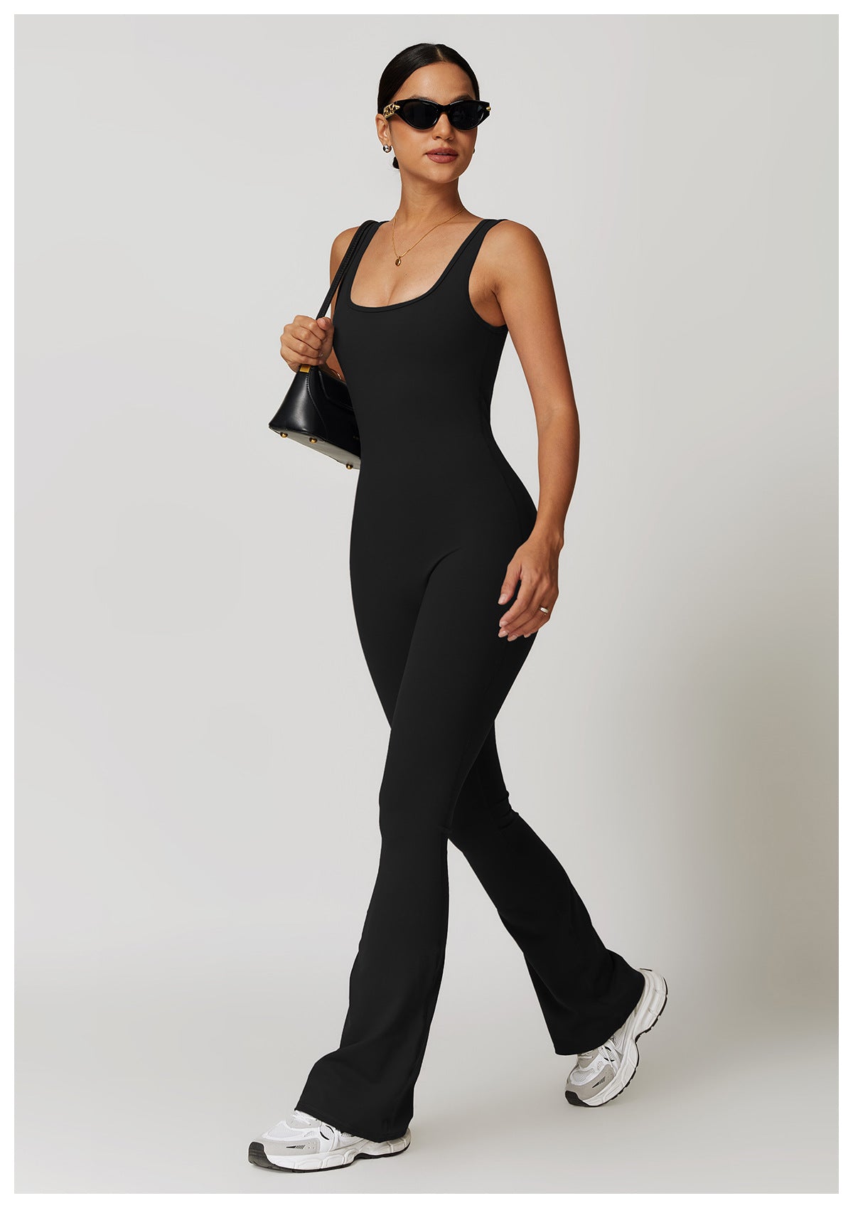 Black sleeveless flared jumpsuit in fashion with white sneakers and sunglasses for ملابس
