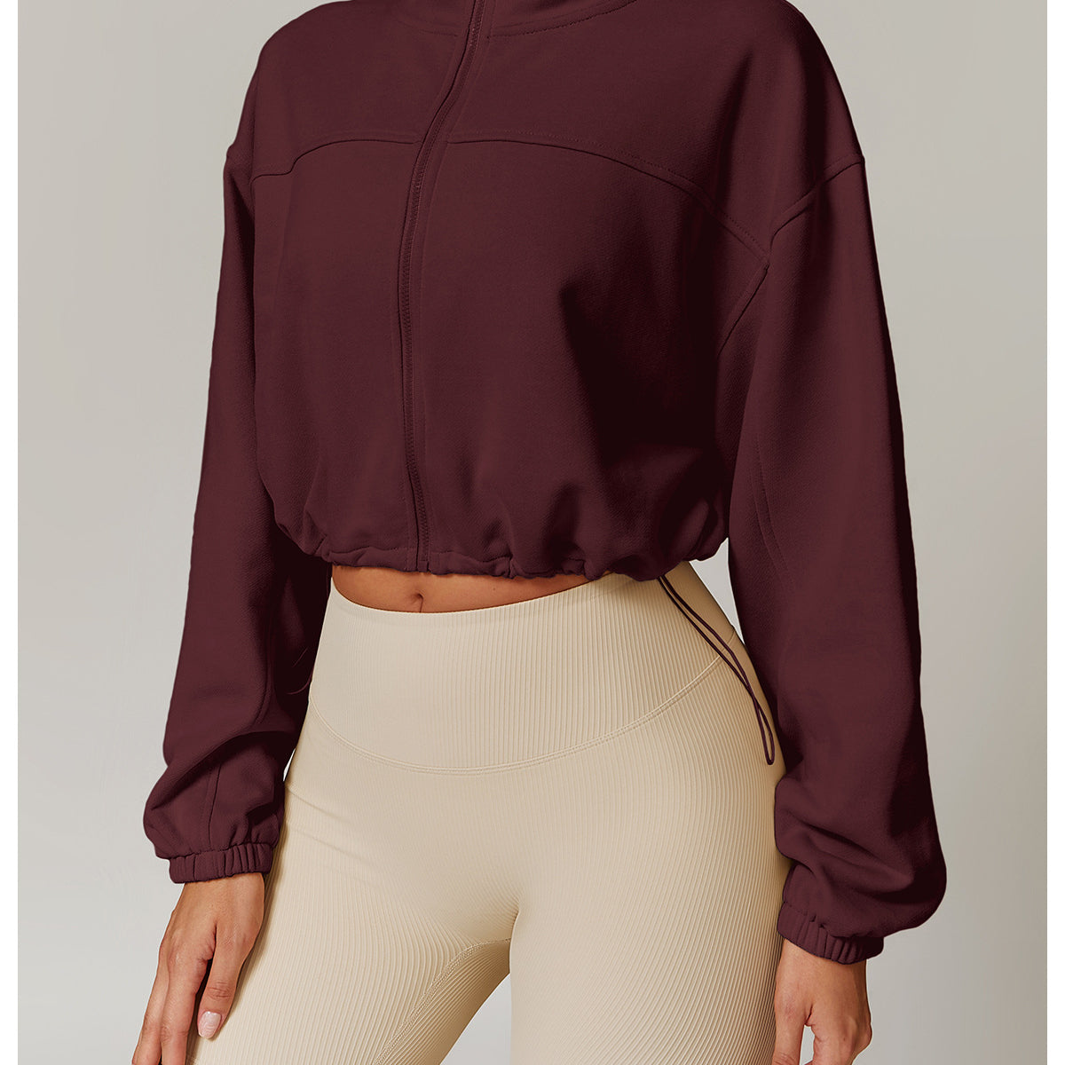 Burgundy cropped zip-up sweatshirt with balloon sleeves and beige biker shorts for fashion