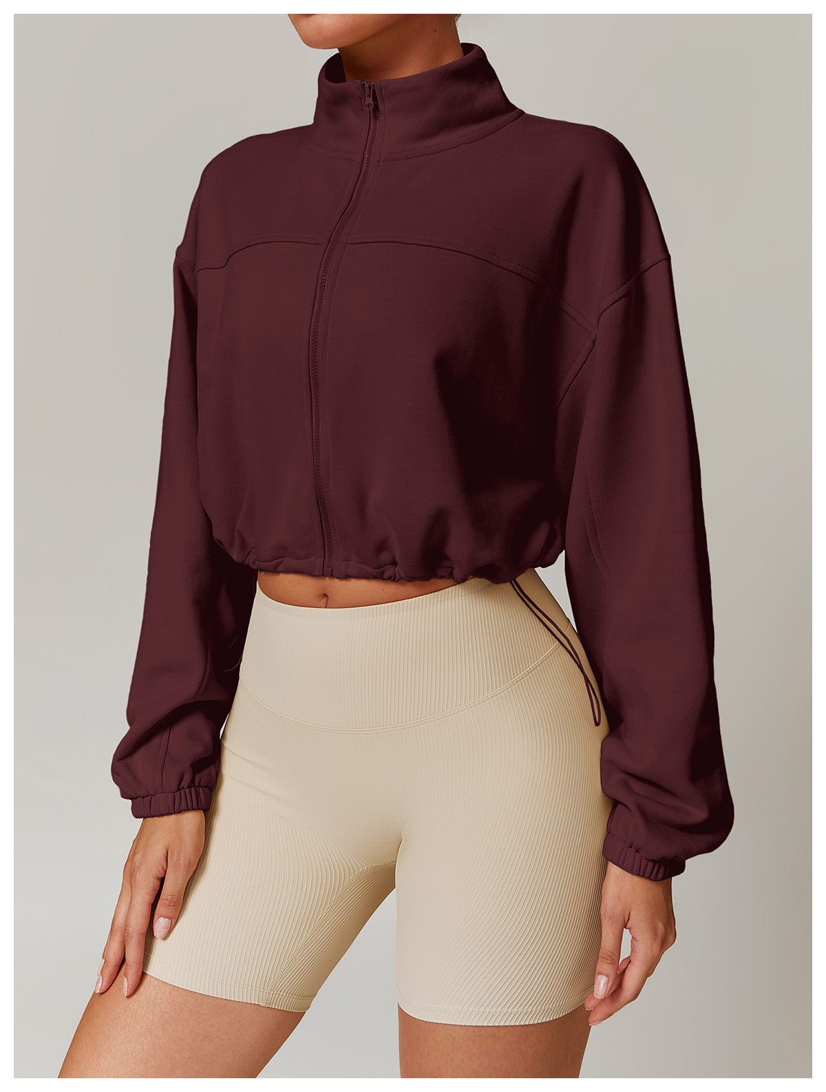 Burgundy cropped zip-up sweatshirt with balloon sleeves and beige biker shorts for fashion