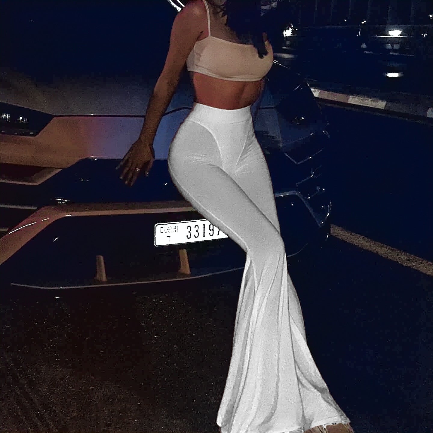 Woman wearing white bell-bottom pants from Langry fashion collection showcasing stylish ملابس