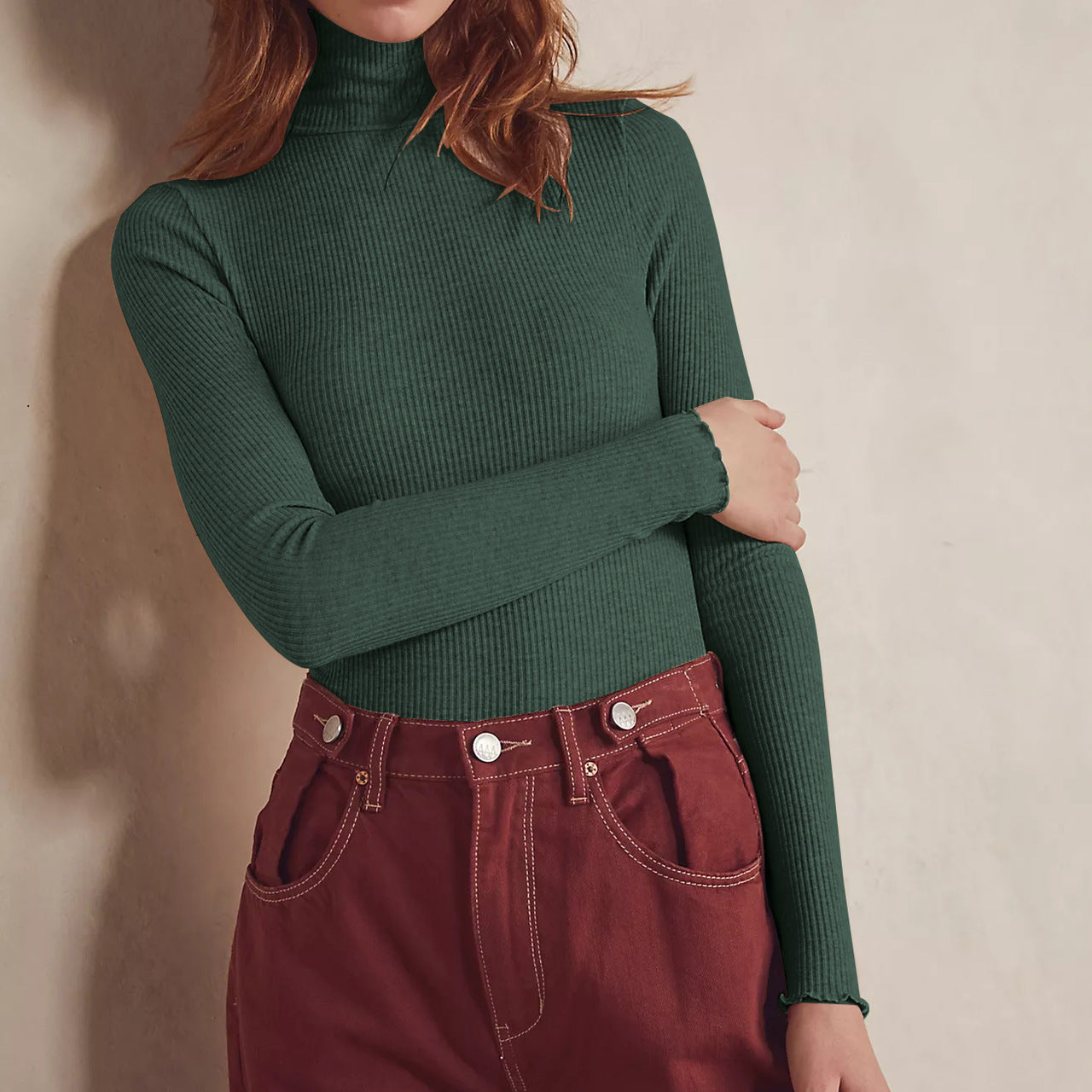Woman in green turtleneck and red pants wearing high collar long sleeve slim rib bodysuit