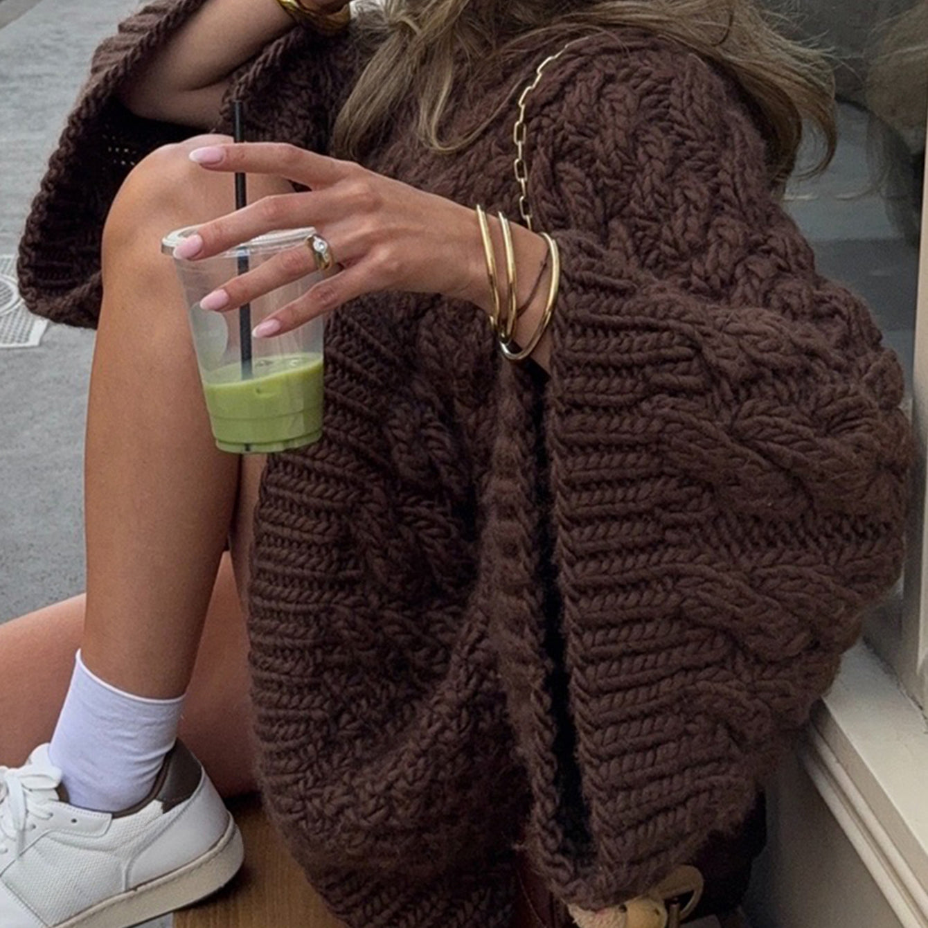 Brown chunky knit oversized long sleeve sweater with pom-pom hem
