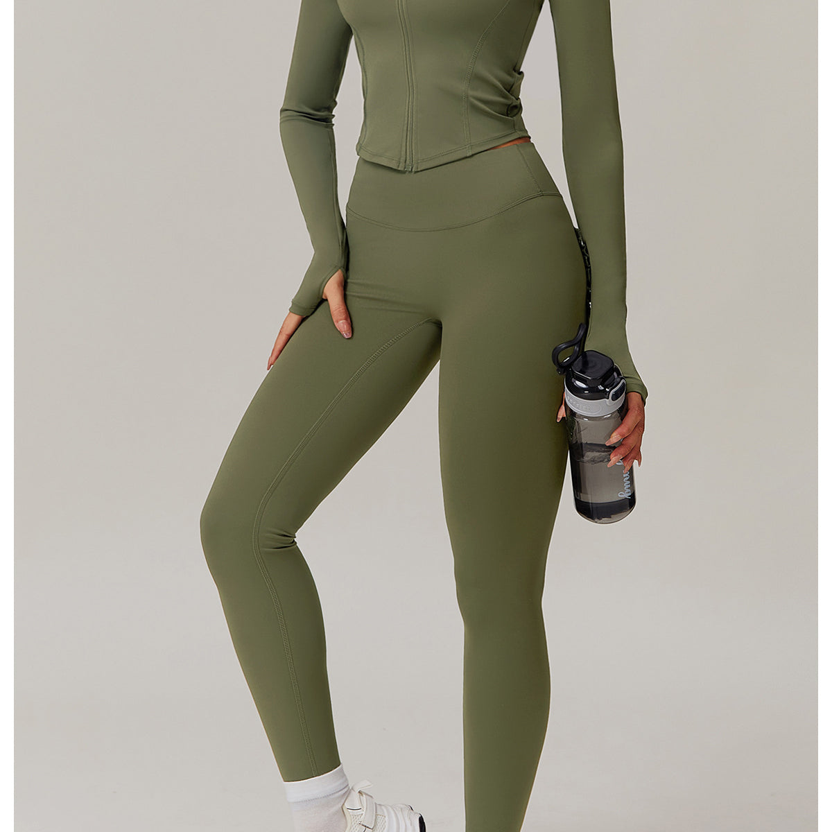 Olive green fitted jumpsuit paired with chunky white sneakers for comfy fashion ملابس