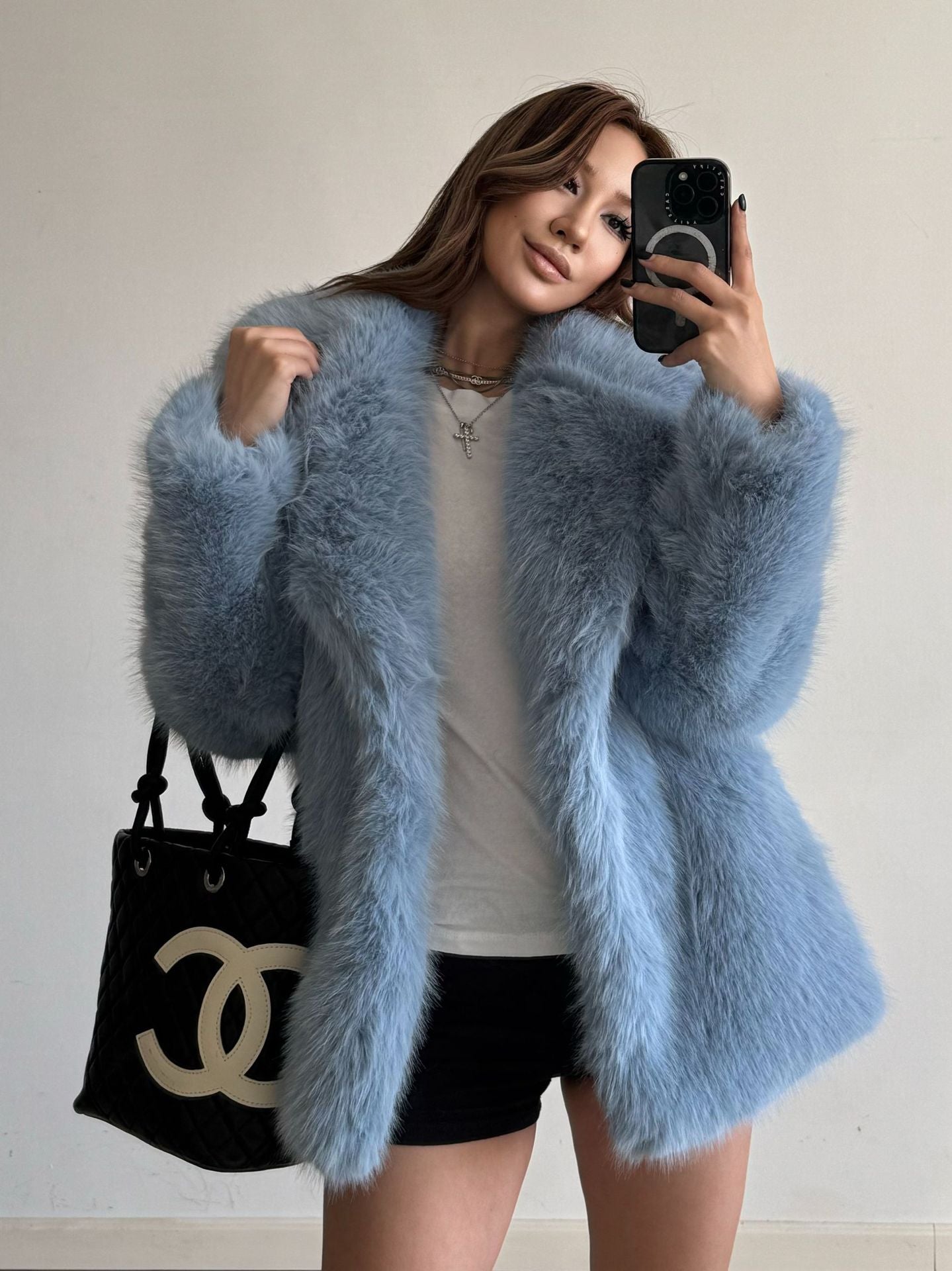 Light blue fluffy faux fur coat with Chanel handbag