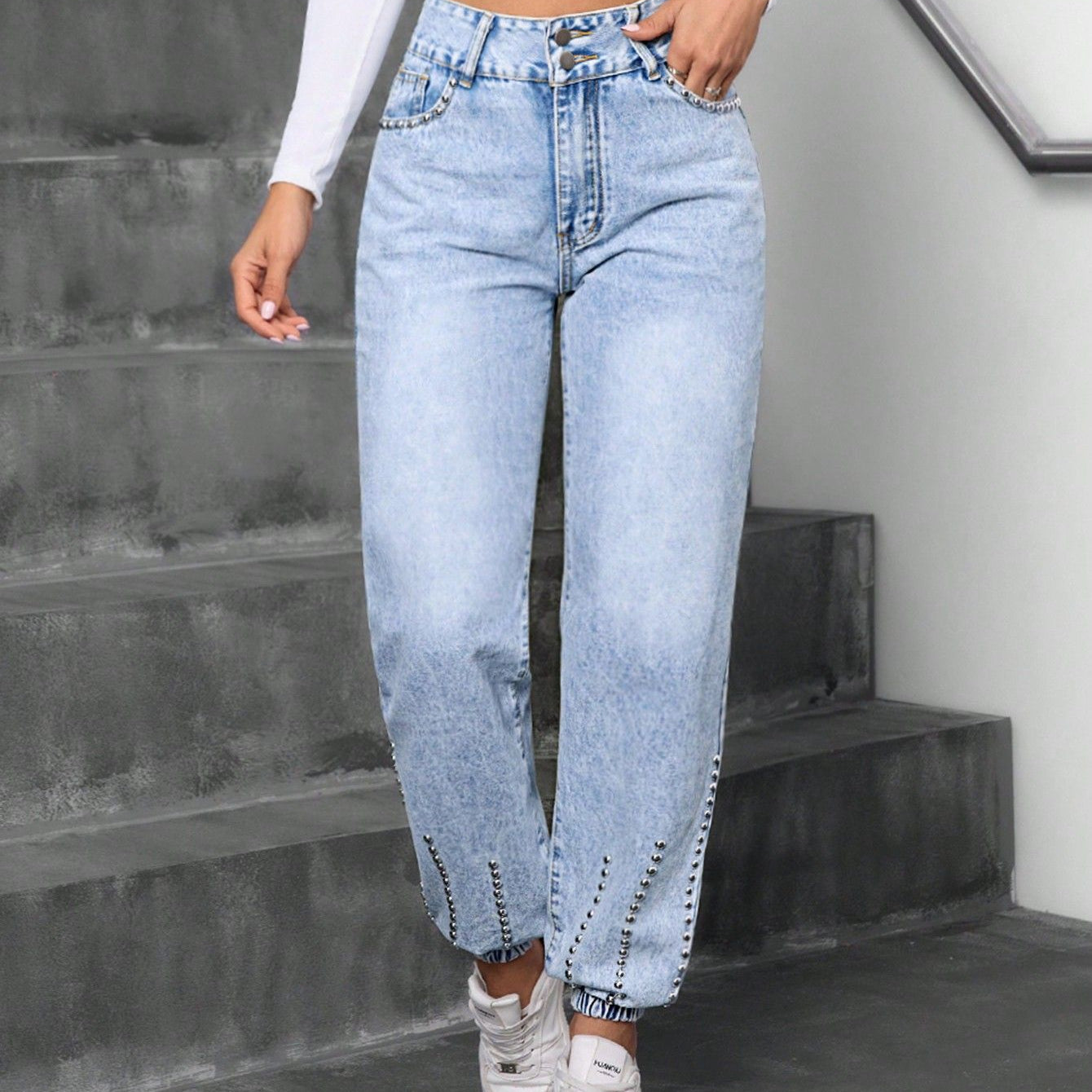 Light wash blue high-waisted baggy jeans with elastic cuffs and studded details, match beaded straight style