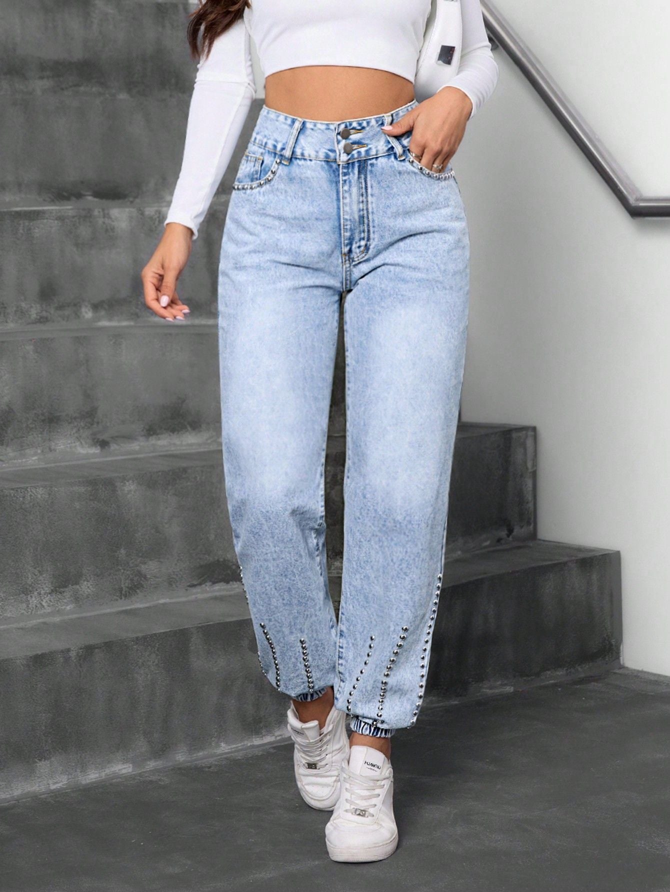 Light wash blue high-waisted baggy jeans with elastic cuffs and studded details, match beaded straight style
