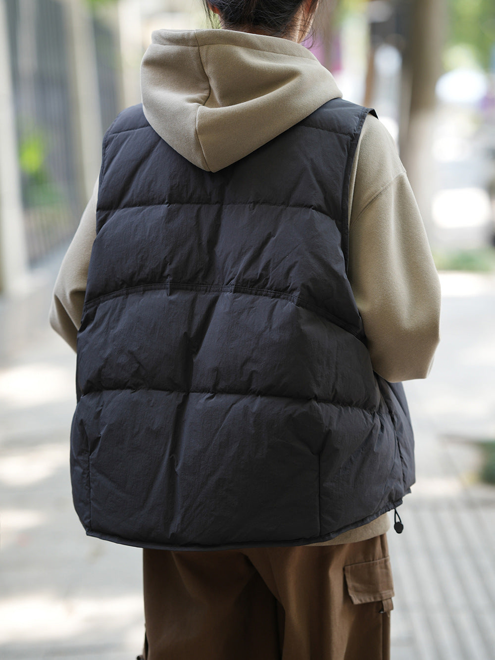 Black puffy winter vest over beige hoodie, ideal for Langry fashion ملابس in cold weather
