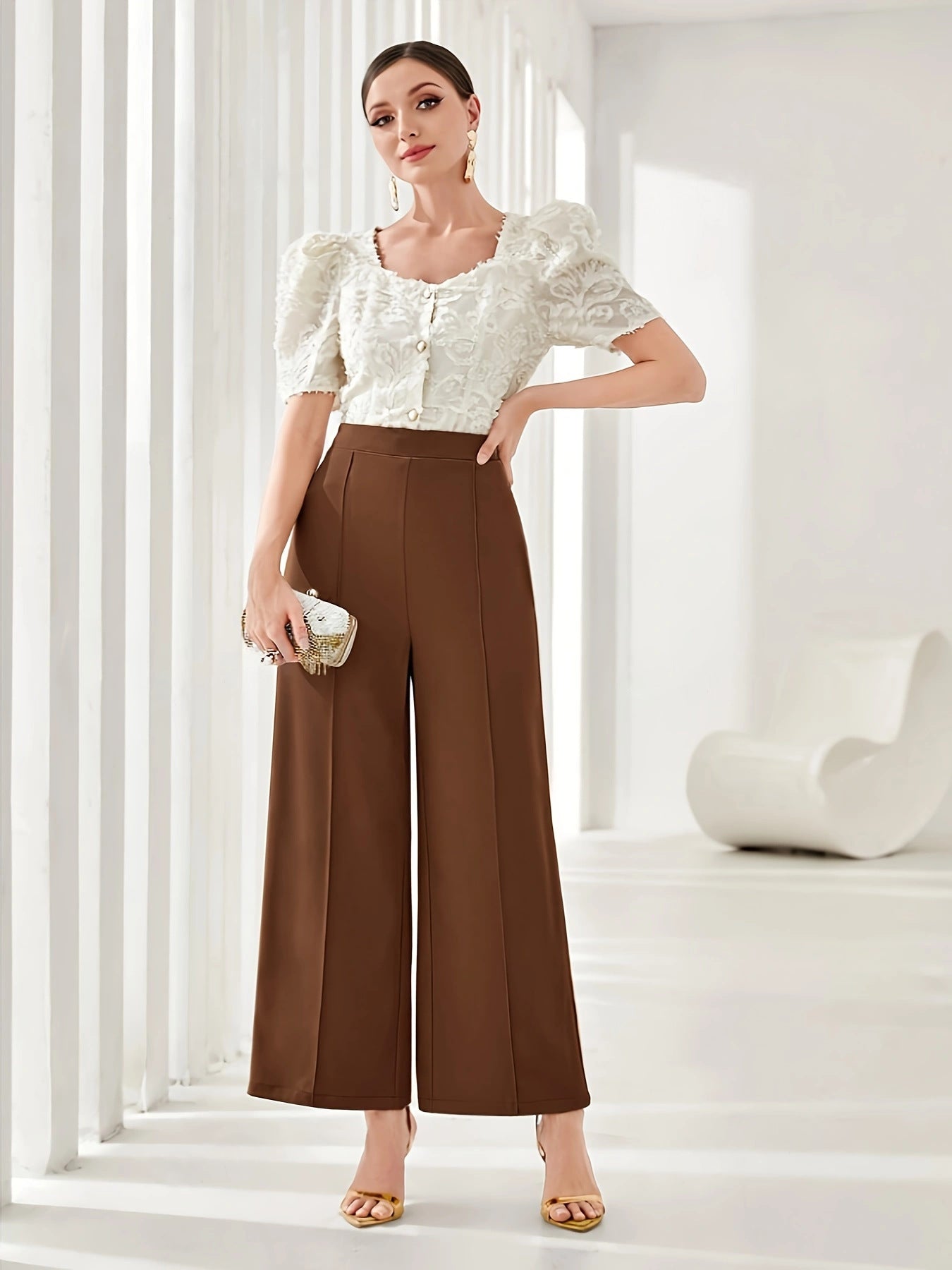 High-waisted brown palazzo pants with a white puff-sleeve crop top in elegant fashion