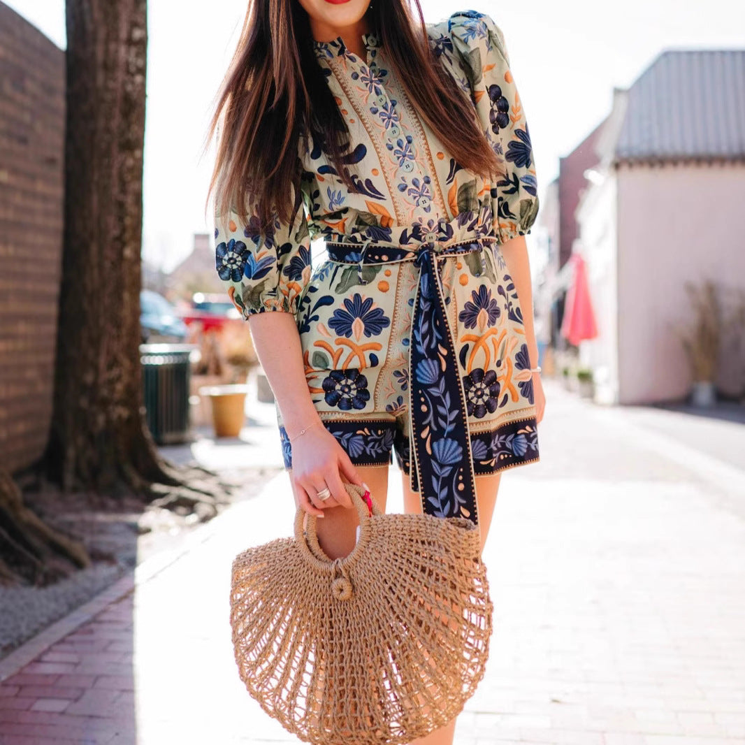 Floral-patterned romper paired with a straw handbag in stunning Bohemian fashion ملابس