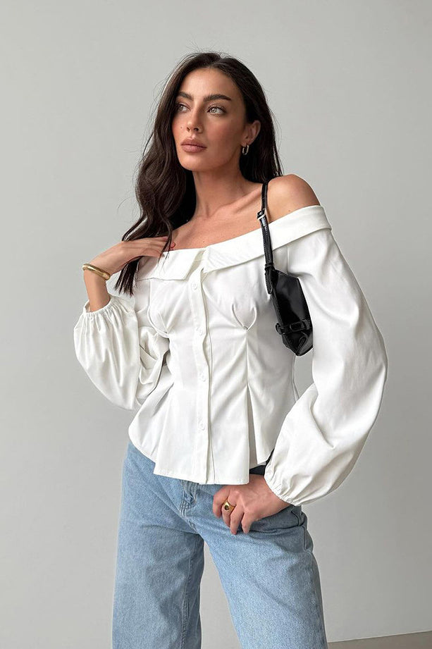 Elegant French off-shoulder shirt styled with billowy sleeves and light blue jeans for fashion