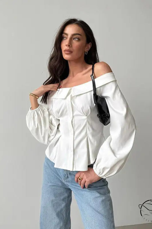 Elegant French off-shoulder shirt with billowy sleeves and light blue jeans