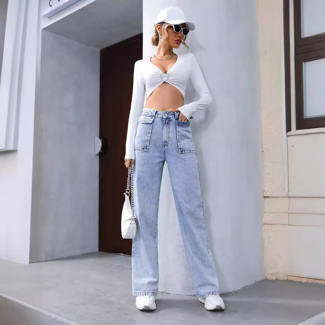 Woman in white crop top and light wash denim trousers with sunglasses, fashionable style