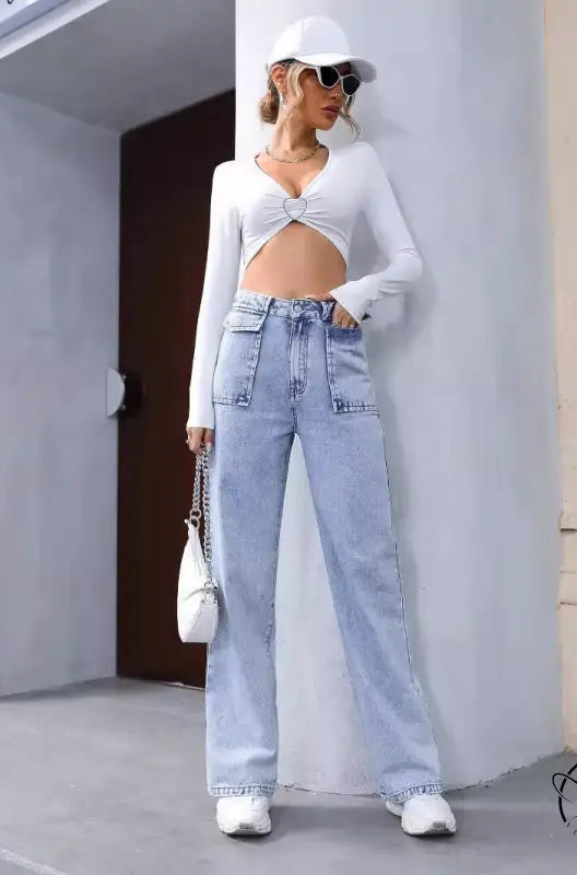 Woman in white crop top and Langry denim trousers with baseball cap