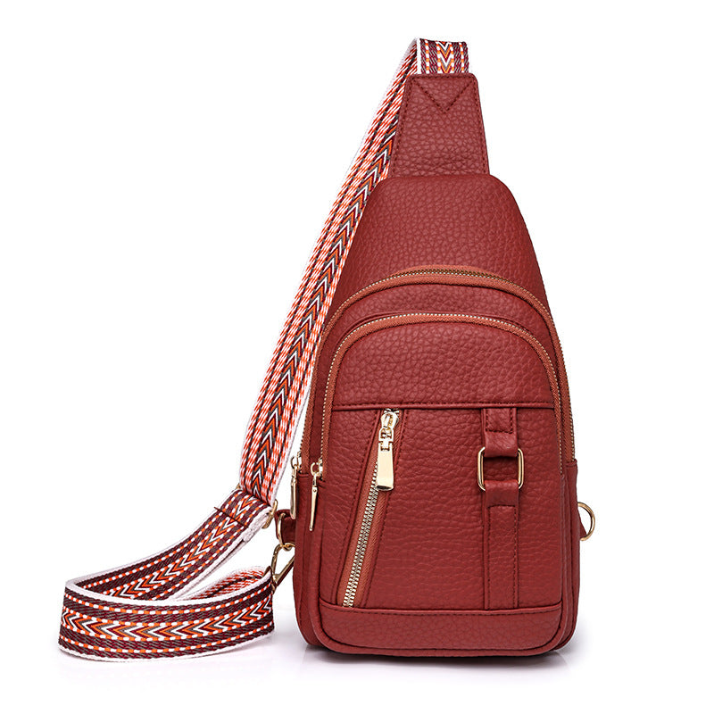 Reddish-brown faux leather sling bag with patterned strap, perfect for trendy fashion styles