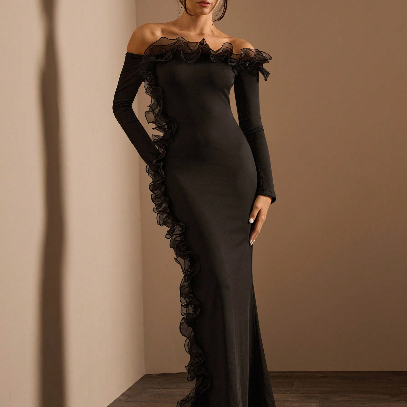 Elegant black off-the-shoulder maxi dress with ruffled trim showcasing stylish fashion