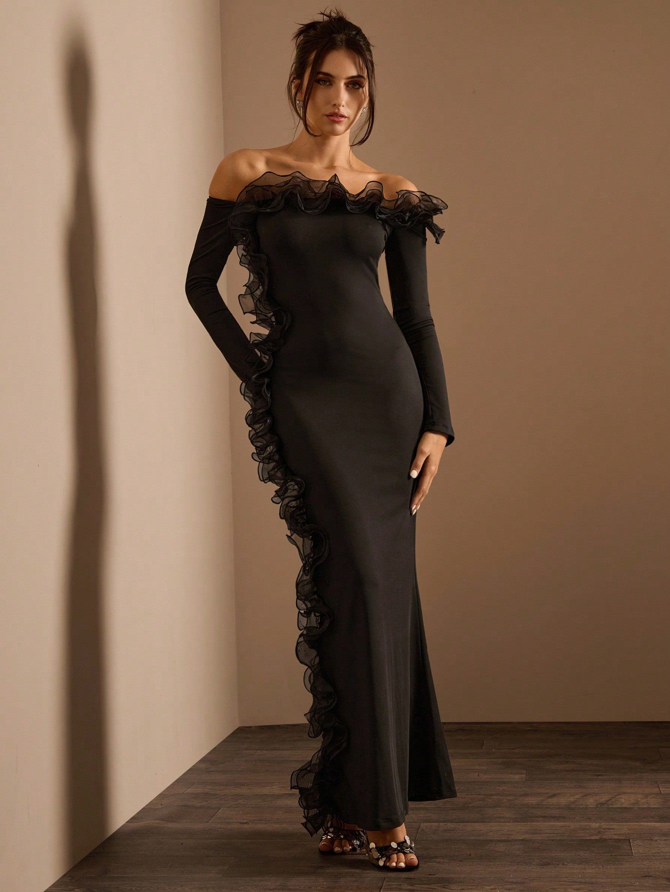Elegant black off-the-shoulder maxi dress with ruffled trim showcasing stylish fashion