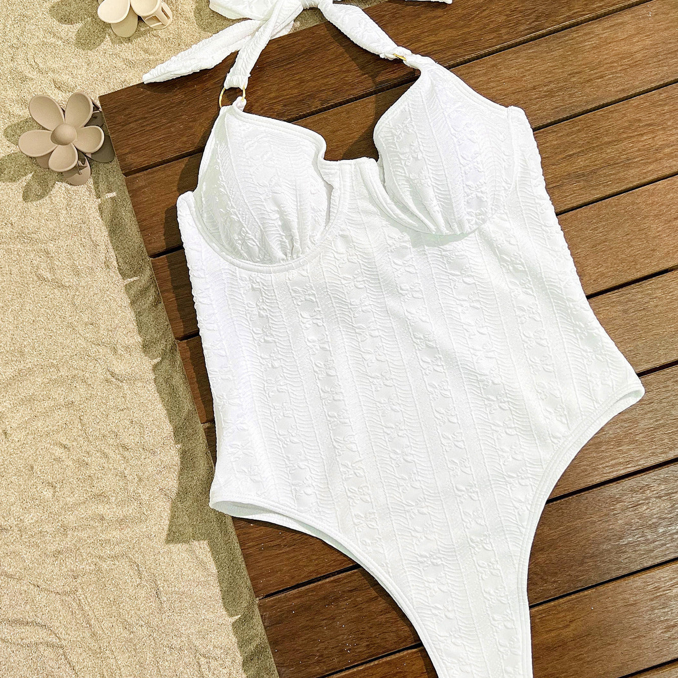 White halter-neck one-piece swimsuit with textured fabric, perfect for elegant summer fashion