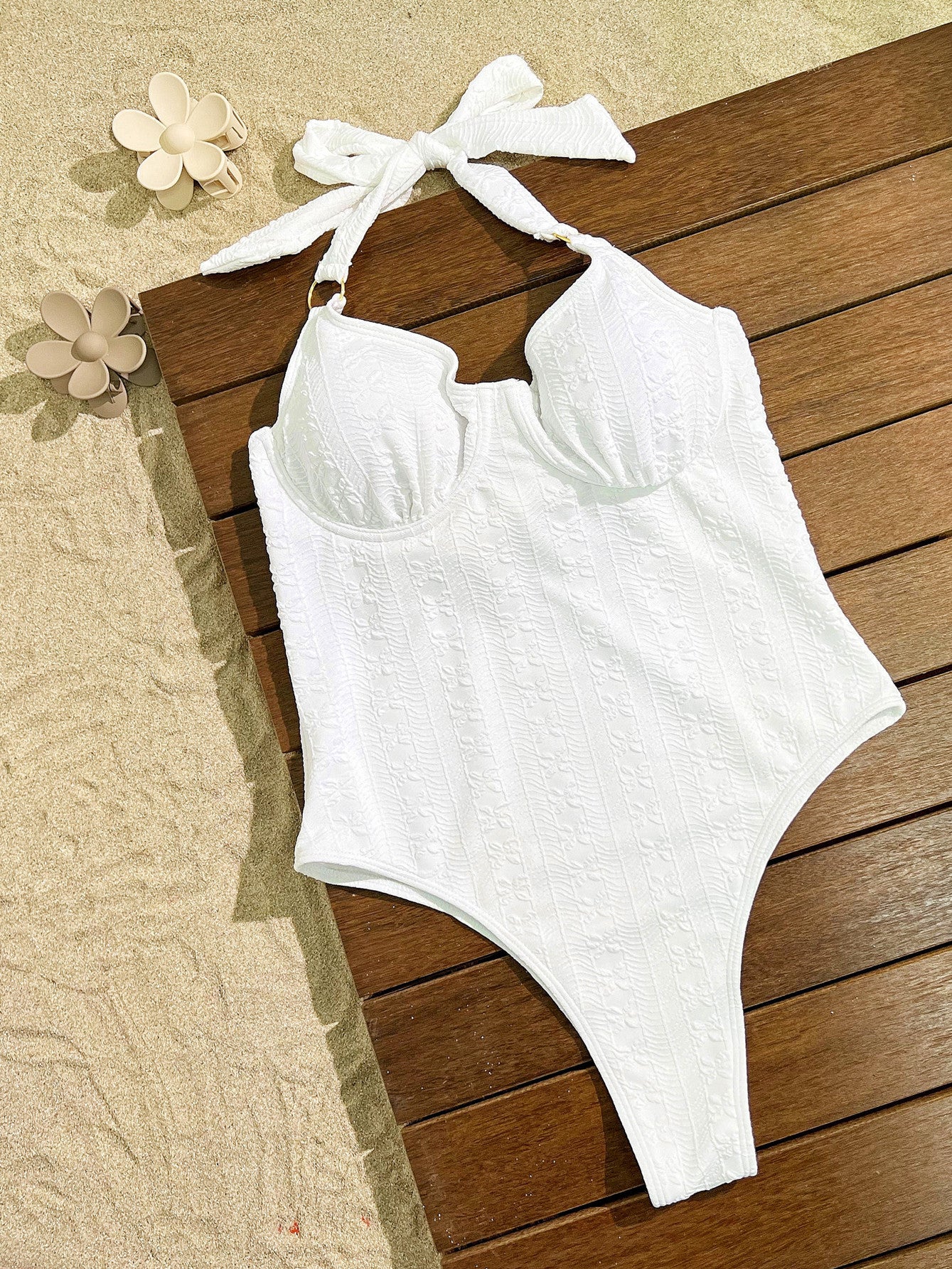 White halter-neck one-piece swimsuit with textured fabric, perfect for elegant summer fashion
