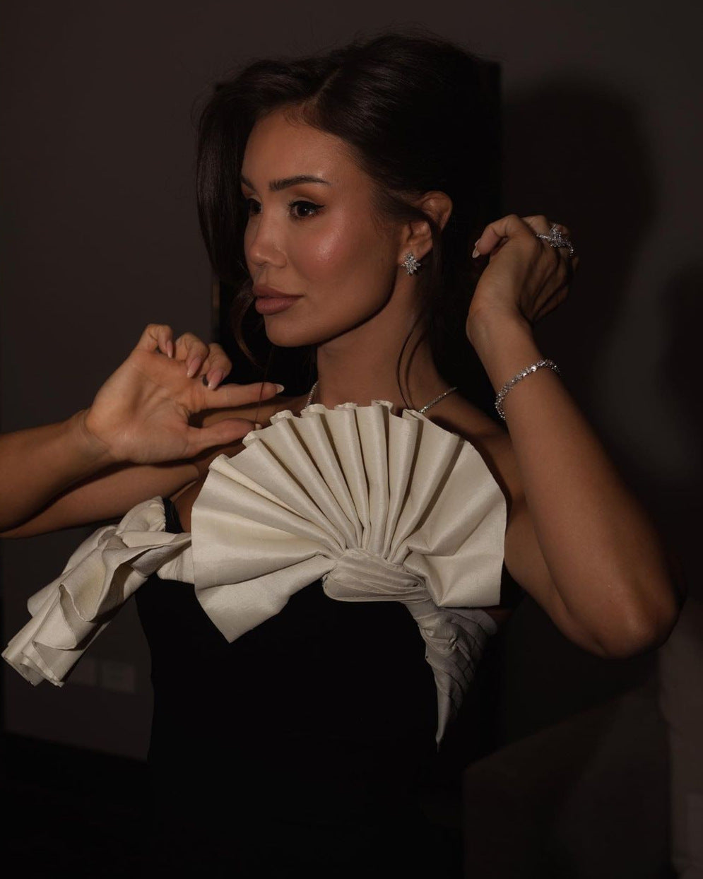 Elegant white pleated bow detail on a black strapless dress in fashion ملابس