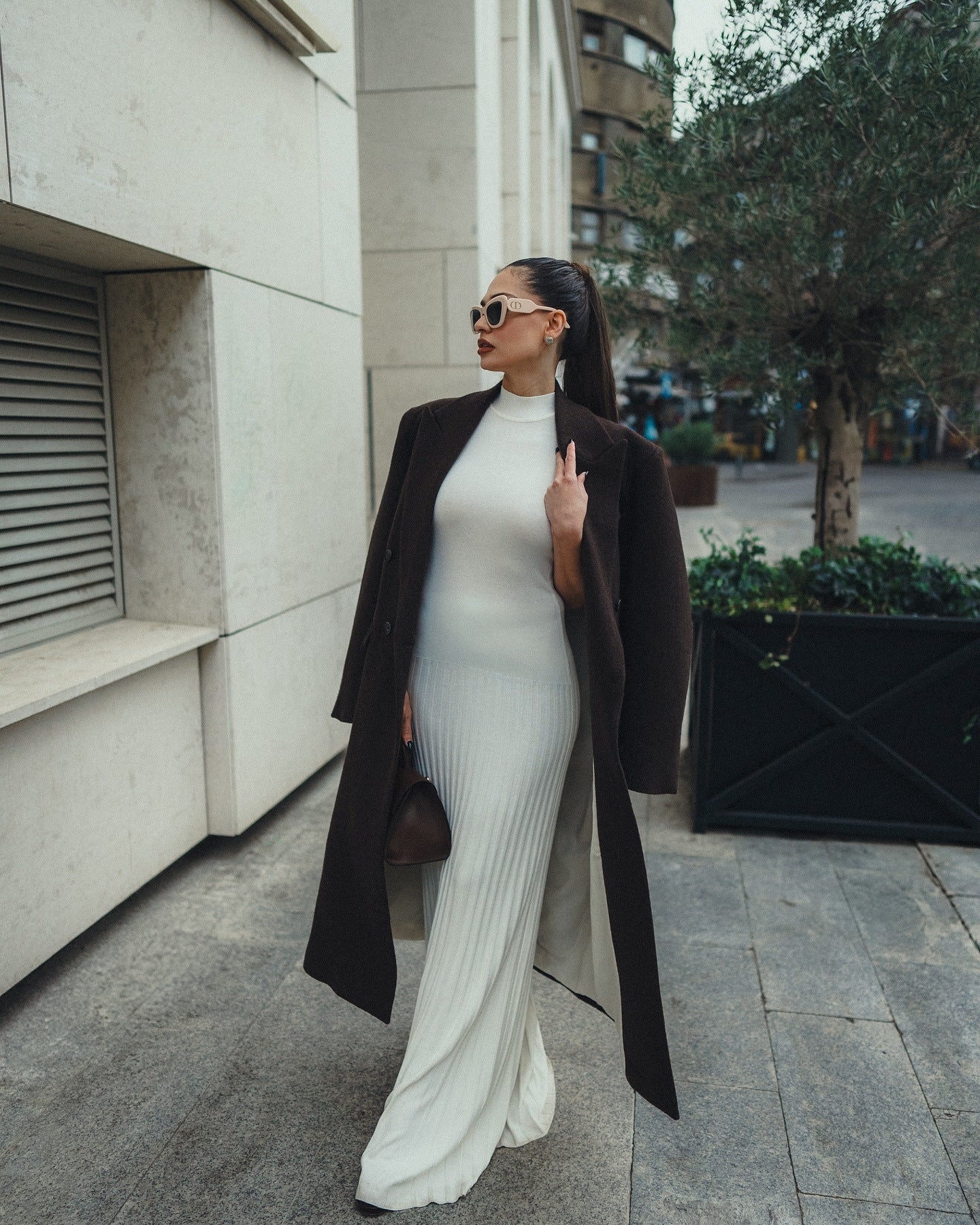 Elegant white ribbed maxi dress with black coat and sunglasses for stylish fashion look