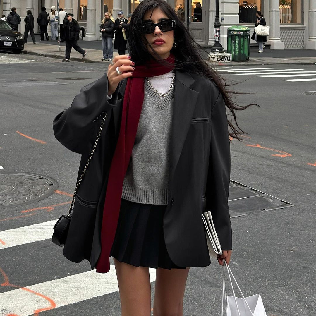 Stylish winter fashion featuring a gray sweater and burgundy scarf with black skirt and blazer