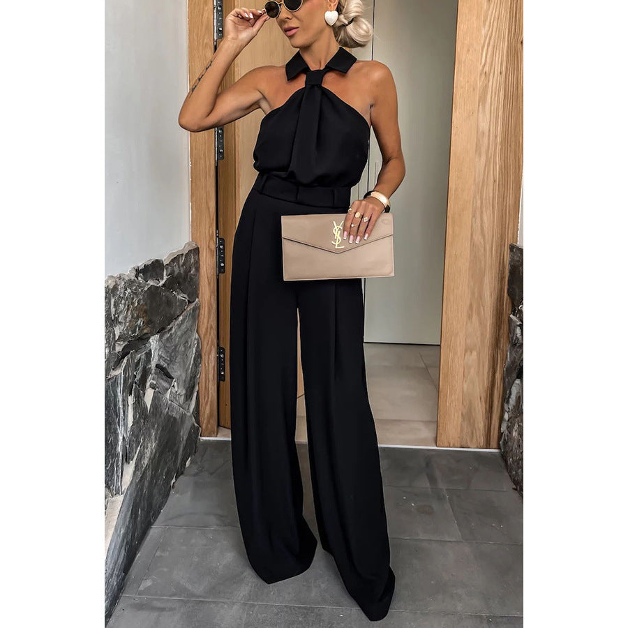Black halter jumpsuit with beige clutch, perfect for summer casual fashion and ملابس