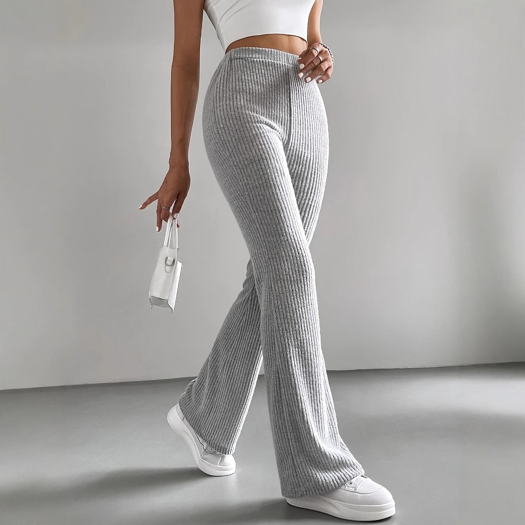 Casual knitted match pants with flared gray design, white sneakers, and white handbag
