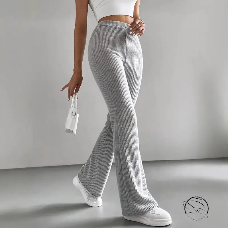 Person in casual knitted match pants, white sneakers, small white handbag