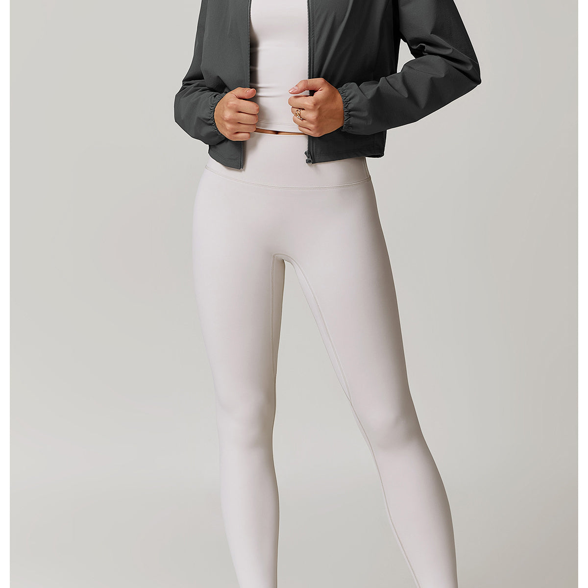 Athletic outfit with dark bomber jacket and light gray leggings, perfect for active fashion
